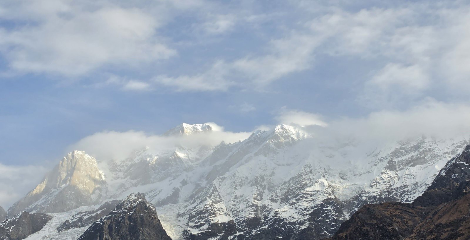 Snow-covered Himalayan peaks above Kedarnath, wrapped in morning cloud
